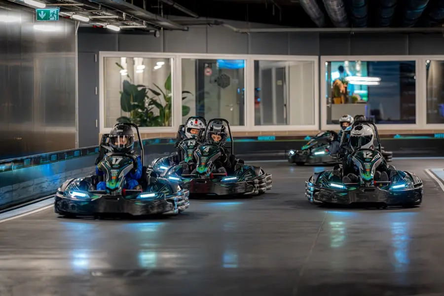 Three electric karts racing past the lounge windows